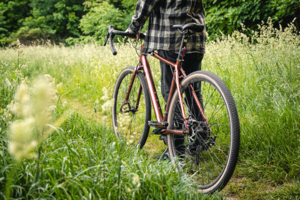 A man with a bike on a summer forest road, summer active vacation.